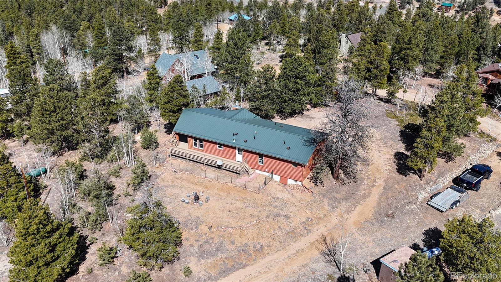 53 O'Brien Road Bailey, CO 80421 - Photo 44 of 49 an aerial view of a yard with table and chairs