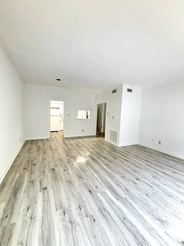 a view of empty room with wooden floor