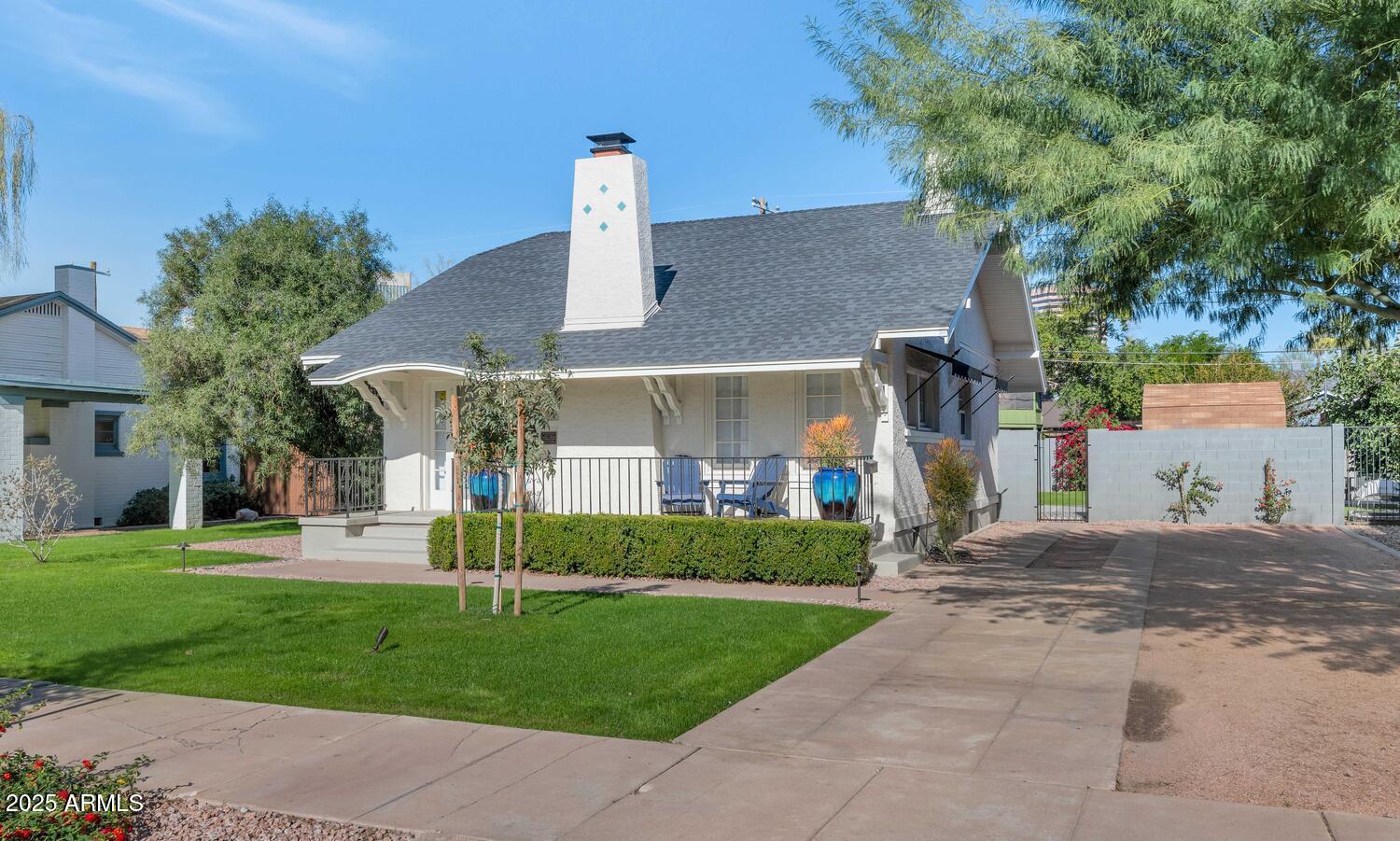 a front view of a house with a garden and trees