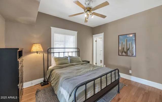 a bedroom with a bed a dresser and a chandelier