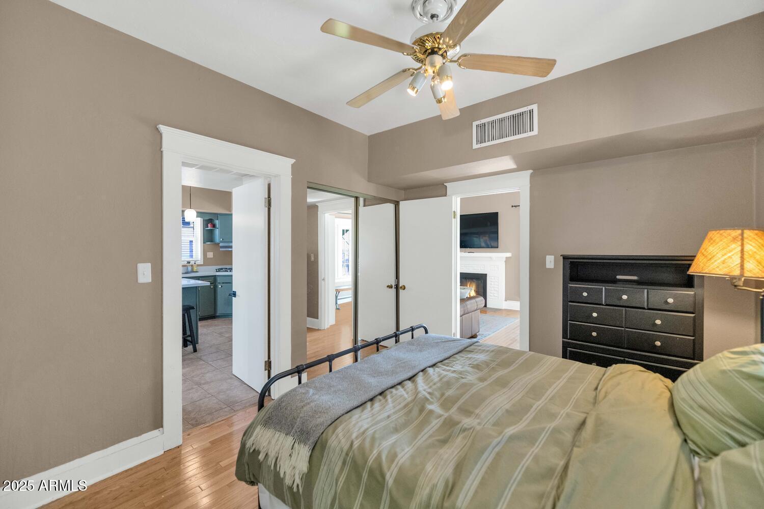 60 East Hoover Avenue Phoenix, AZ 85004 - Photo 12 of 24 a bedroom with a bed a dresser and a chandelier