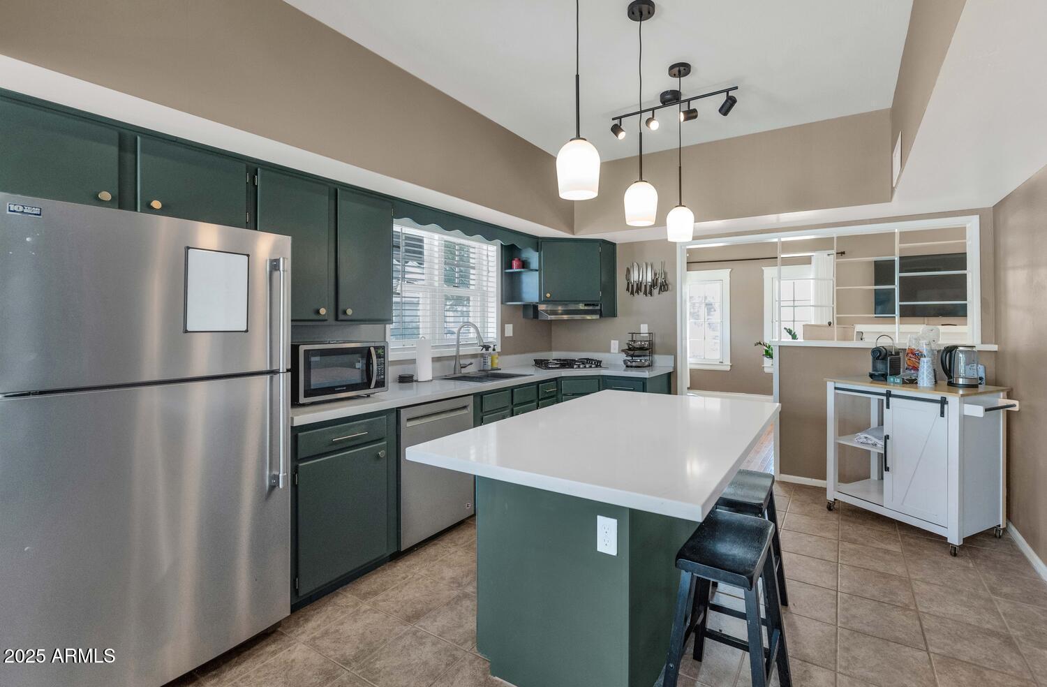 60 East Hoover Avenue Phoenix, AZ 85004 - Photo 10 of 24 a kitchen with kitchen island a sink a stove a refrigerator and white cabinets