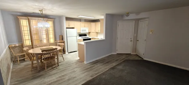 a living room with stainless steel appliances granite countertop furniture and wooden floor