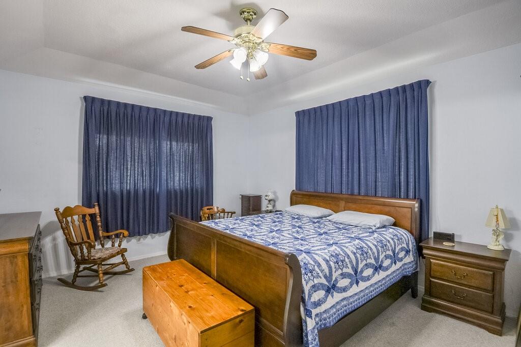 111 Kirk Road Midlothian, TX 76065 - Photo 16 of 40 a bedroom with a bed and a chandelier