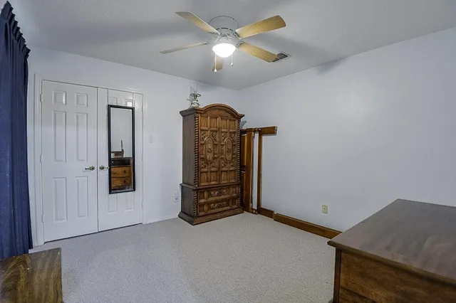an empty room with closet and windows