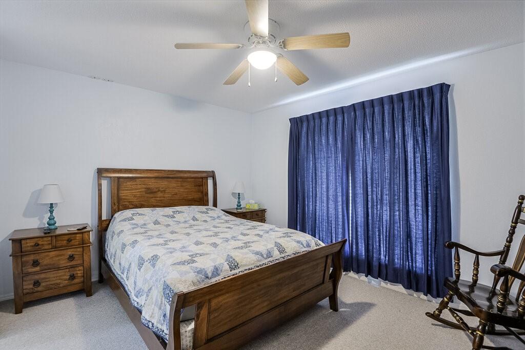 111 Kirk Road Midlothian, TX 76065 - Photo 20 of 40 a bedroom with a bed and a chandelier