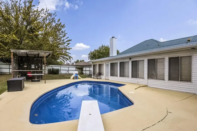 a view of a house with swimming pool and sitting area