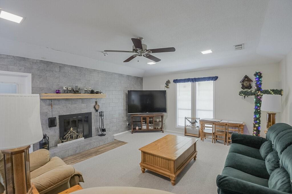 111 Kirk Road Midlothian, TX 76065 - Photo 4 of 40 a living room with furniture a fireplace and a flat screen tv