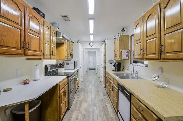 a kitchen with stainless steel appliances a sink stove and cabinets