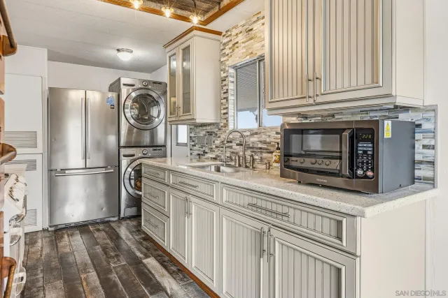 a kitchen with stainless steel appliances granite countertop a refrigerator and a stove