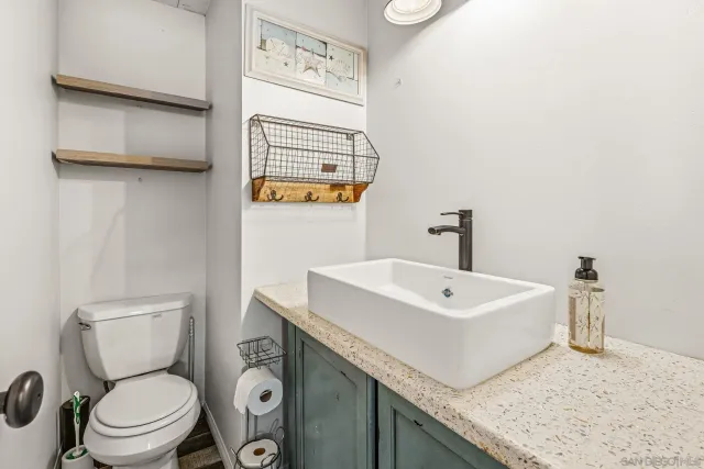 a bathroom with a sink a toilet and mirror