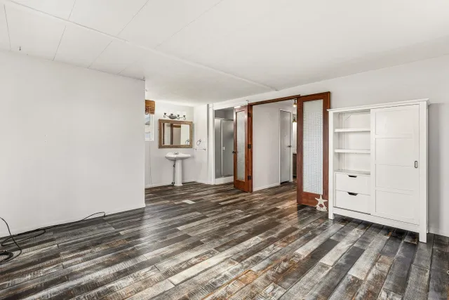 a view of empty room with wooden floor