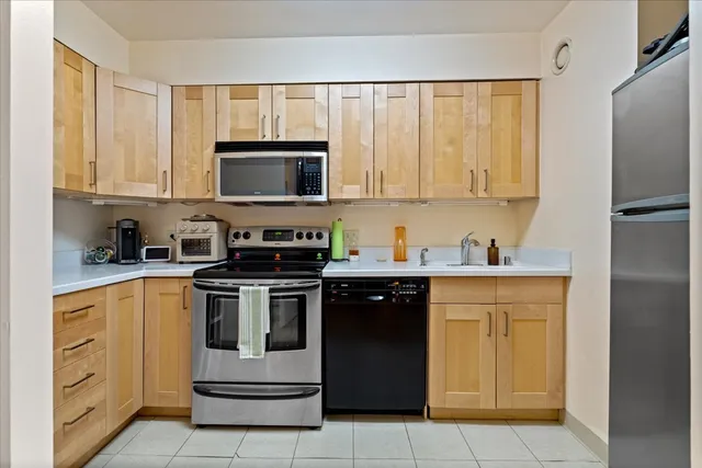 a kitchen with granite countertop a stove top oven microwave and cabinets