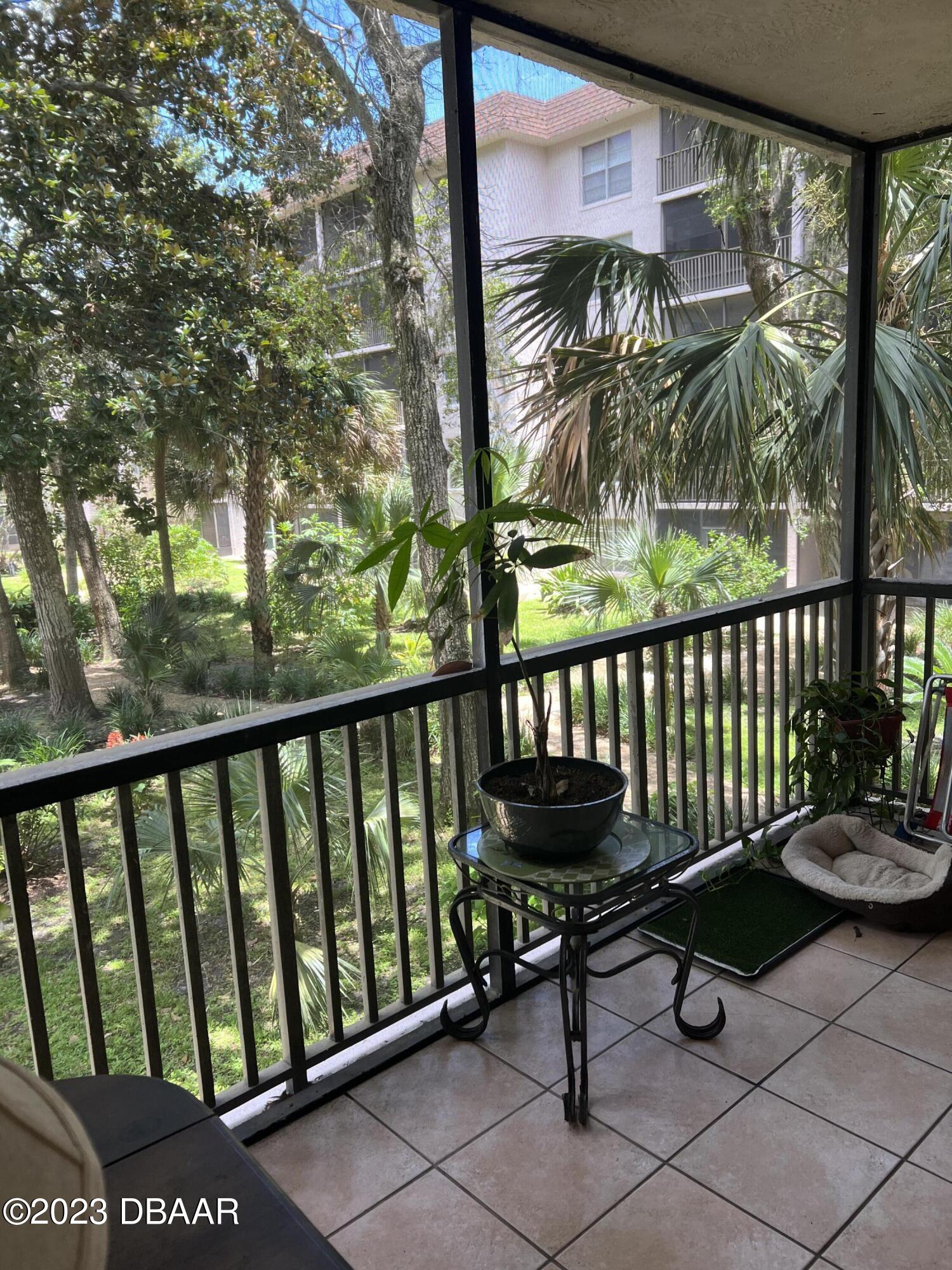 640 North Nova Road, Unit 204 Ormond Beach, FL 32174 - Photo 12 of 17 a view of a chairs and table in a balcony