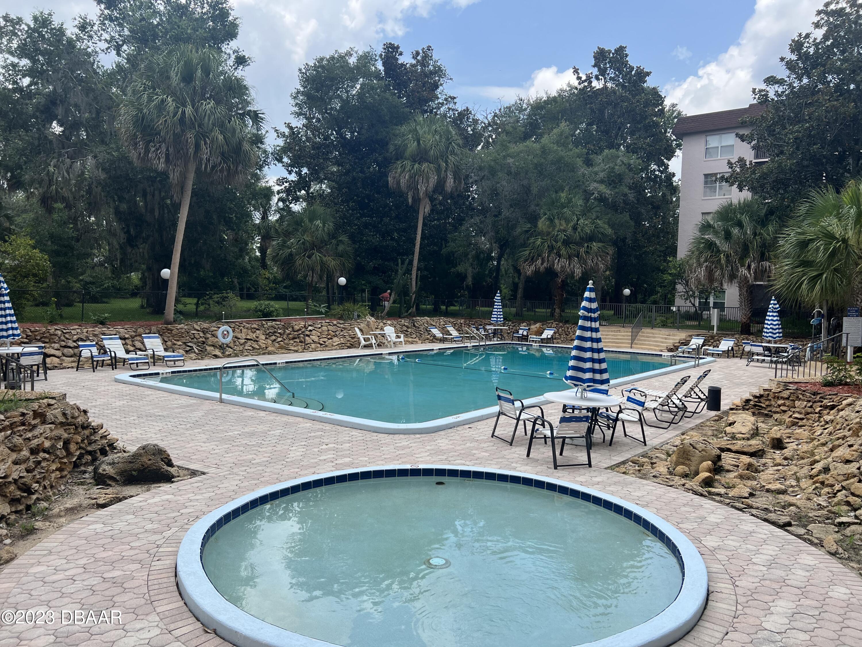 640 North Nova Road, Unit 204 Ormond Beach, FL 32174 - Photo 15 of 17 a view of a swimming pool with lawn chairs and plants