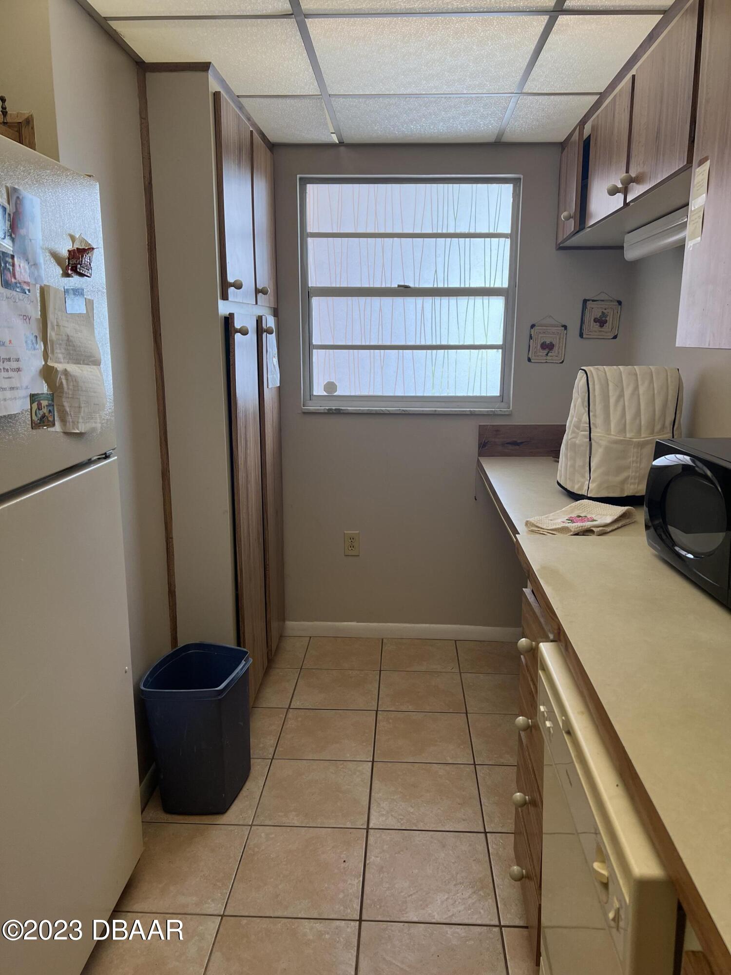 640 North Nova Road, Unit 204 Ormond Beach, FL 32174 - Photo 4 of 17 a kitchen with a sink cabinets and a window