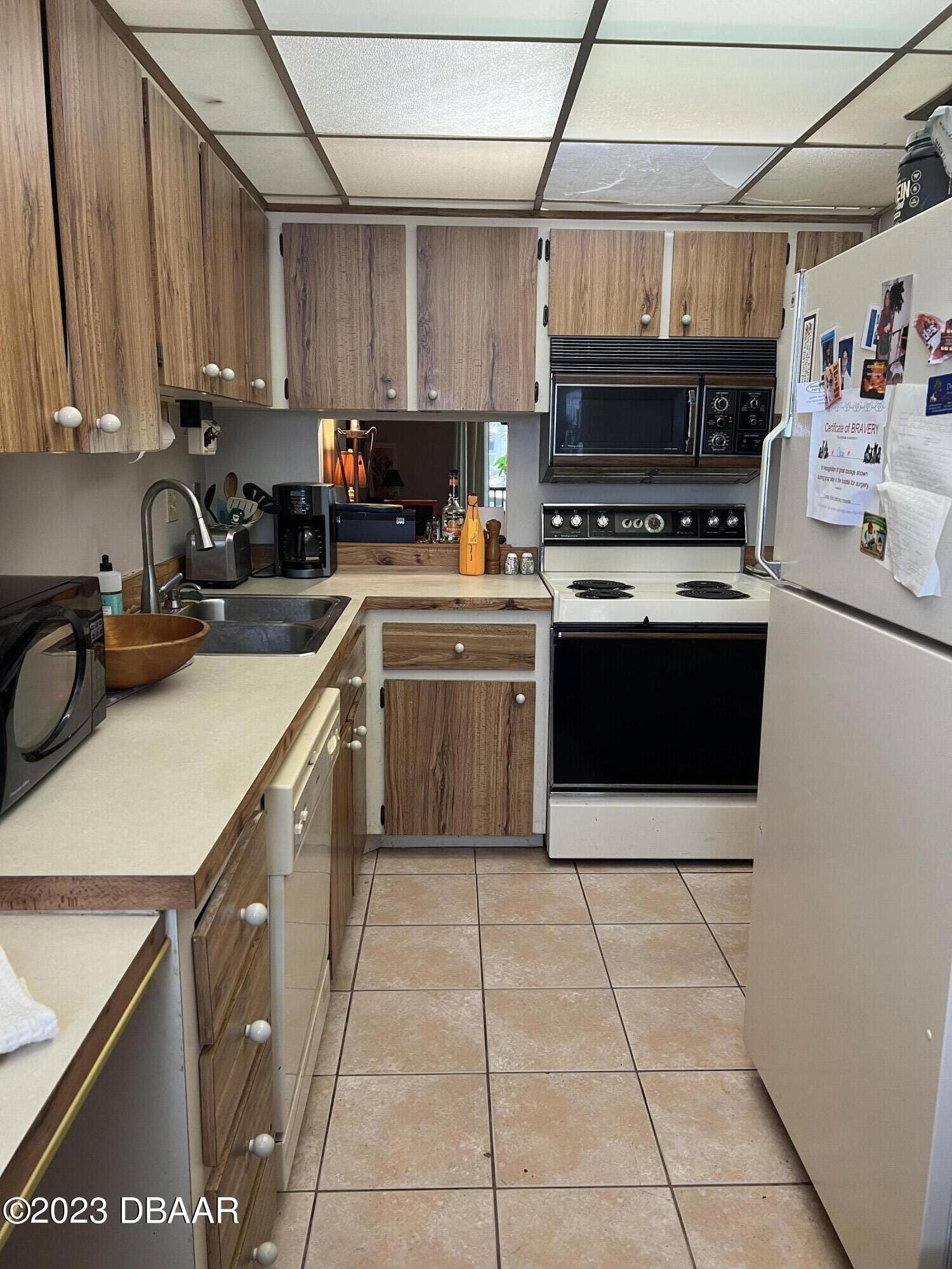 640 North Nova Road, Unit 204 Ormond Beach, FL 32174 - Photo 5 of 17 a kitchen with a sink a stove and cabinets