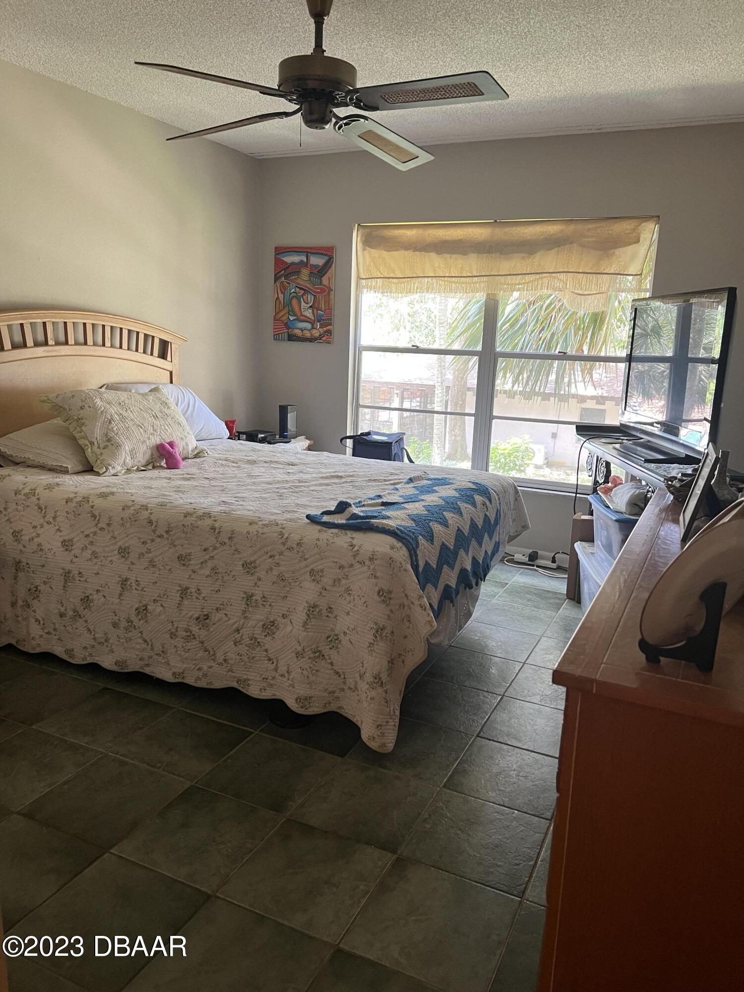 640 North Nova Road, Unit 204 Ormond Beach, FL 32174 - Photo 10 of 17 a bedroom with a bed and a large window