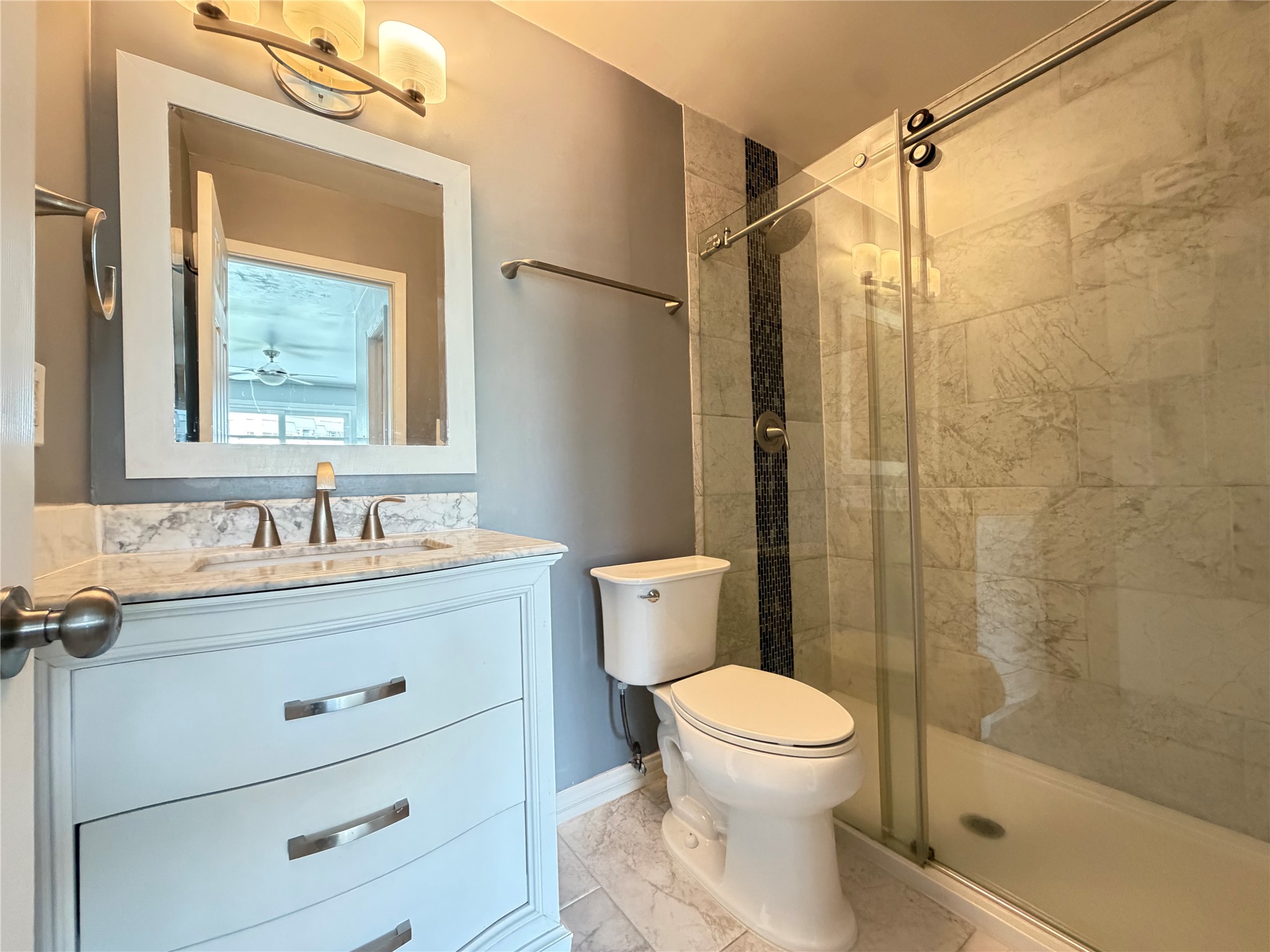 2918 Ranch Road 620 North, Unit C120 Austin, TX 78734 - Photo 20 of 34 A well-appointed primary bath offers a sleek vanity with marble counters, a walk-in shower, tile floors & more.