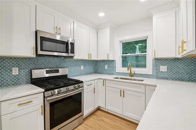 a kitchen with a sink stove and microwave