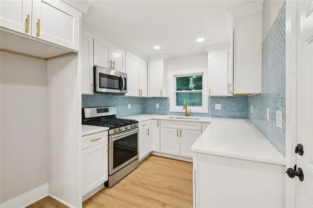 a kitchen with granite countertop a sink a stove top oven and cabinets