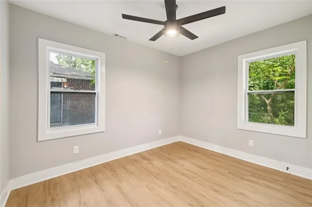 an empty room with a window and wooden floor