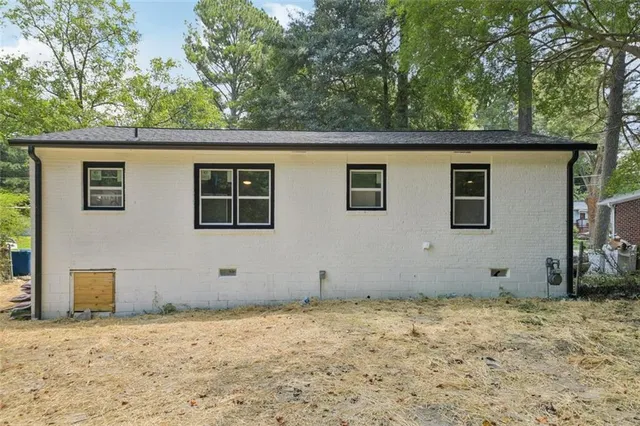 a view of a house with backyard and trees