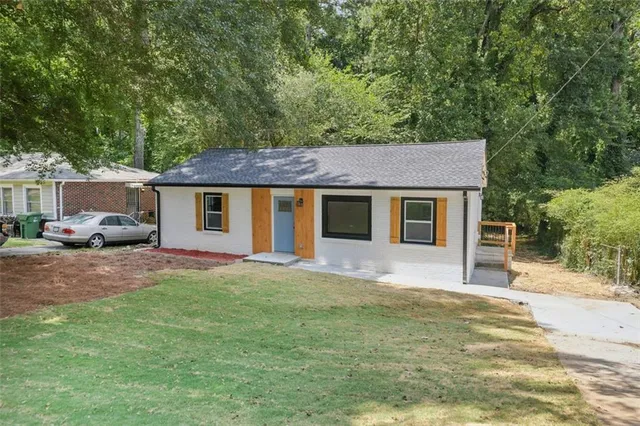 a front view of a house with a garden and yard