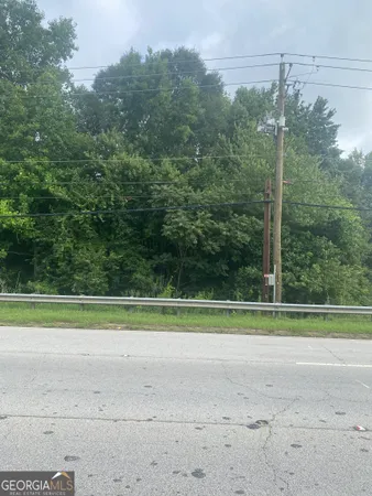 a view of a grassy field with trees in the background