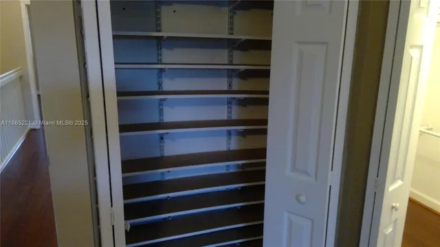 a view of walk in closet with empty racks
