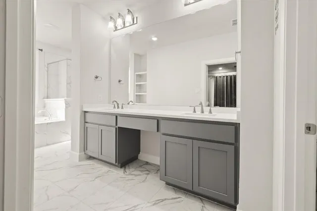 a bathroom with a double vanity sink a mirror and a bathtub