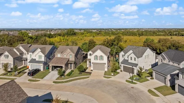 an aerial view of residential houses with outdoor space and ocean view
