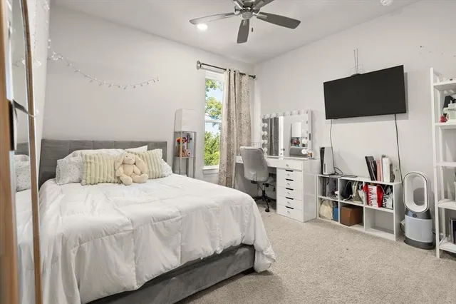 a bedroom with a bed a flat screen tv and a chandelier