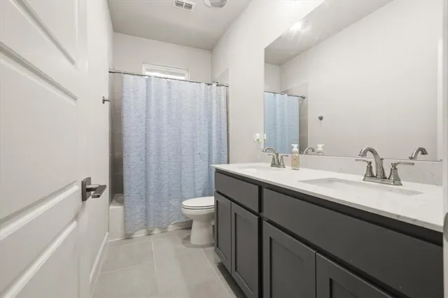 a bathroom with a double vanity sink toilet and shower
