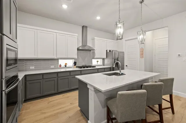 a kitchen with kitchen island a sink table and chairs