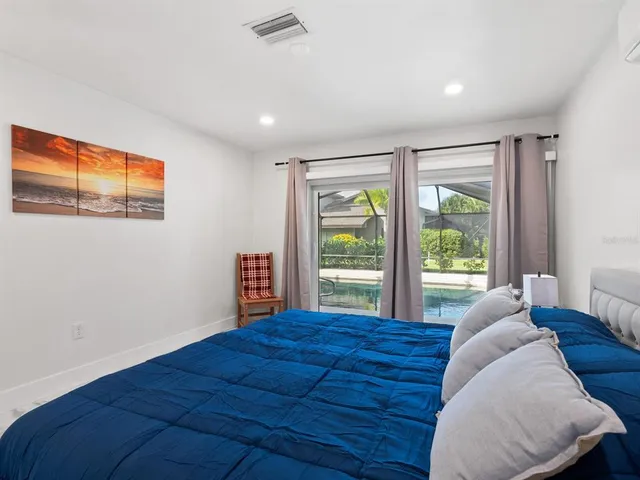 a bed sitting in a spacious bedroom next to a window