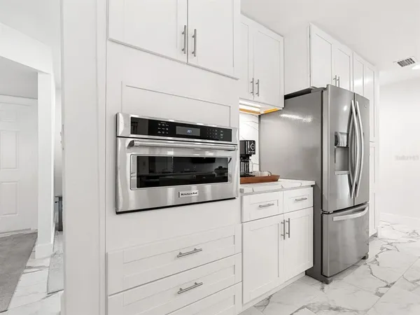 a kitchen with white cabinets and stainless steel appliances