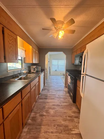 a large kitchen with stainless steel appliances granite countertop a refrigerator and a sink