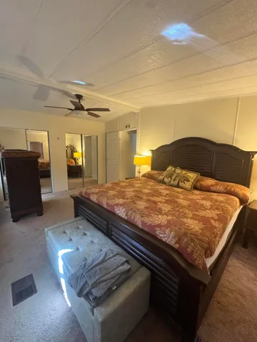 a bed sitting in a spacious bedroom next to a larger window