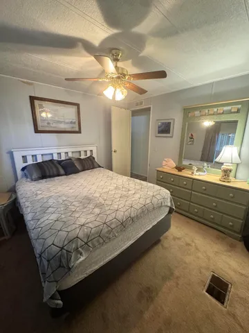 a bedroom with a bed and a mirror on dresser