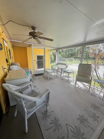 a living room with furniture a flat screen tv and a large window