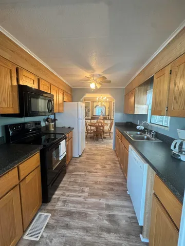 a large kitchen with stainless steel appliances granite countertop a stove refrigerator and a microwave