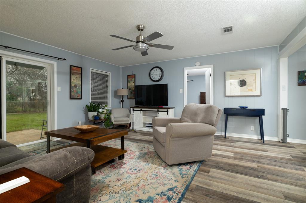 6020 Harrison Way Watauga, TX 76148 - Photo 12 of 32 Living room with a textured ceiling, ceiling fan, and wood finished floors