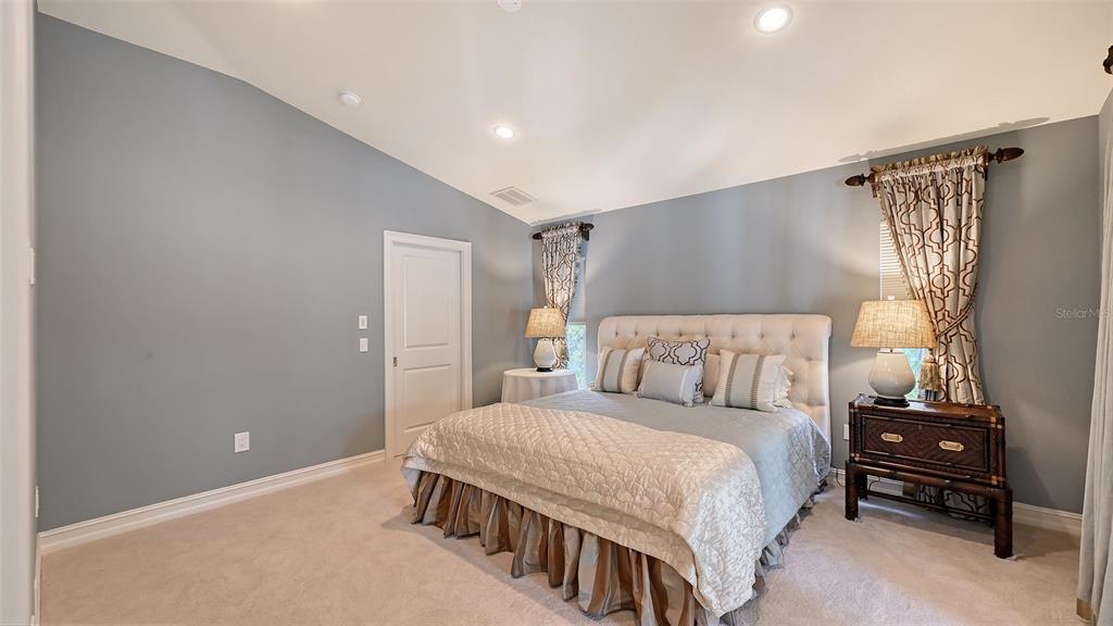 725 Penfield Street Longboat Key, FL 34228 - Photo 13 of 33 a bedroom with a bed and a chandelier