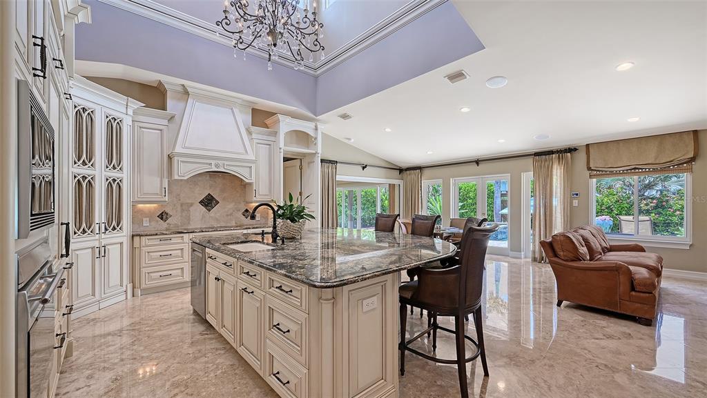 725 Penfield Street Longboat Key, FL 34228 - Photo 5 of 33 a kitchen with stainless steel appliances granite countertop a stove a sink dishwasher and white cabinets with wooden floor