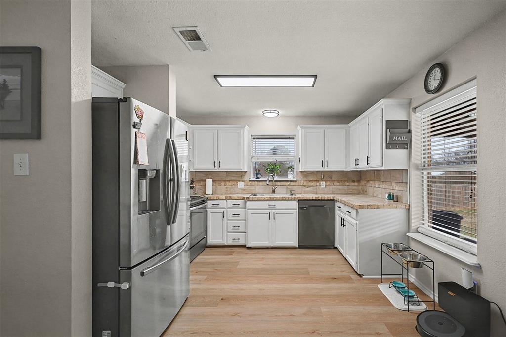 323 Sage Trail Springtown, TX 76082 - Photo 13 of 32 a kitchen with a refrigerator sink and stove