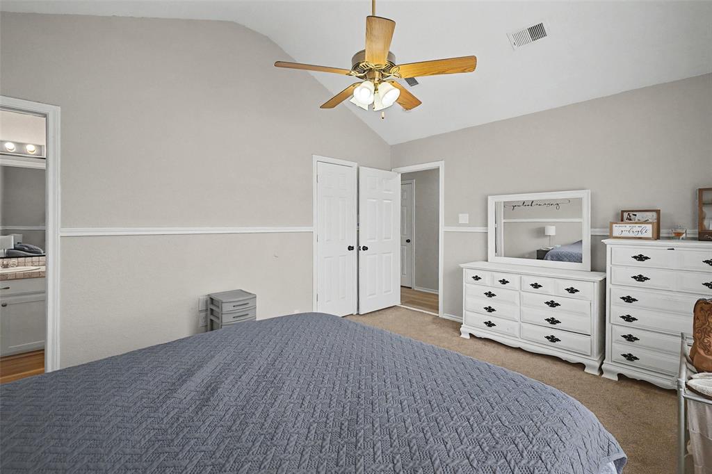 323 Sage Trail Springtown, TX 76082 - Photo 21 of 32 a bedroom with a bed and a chandelier