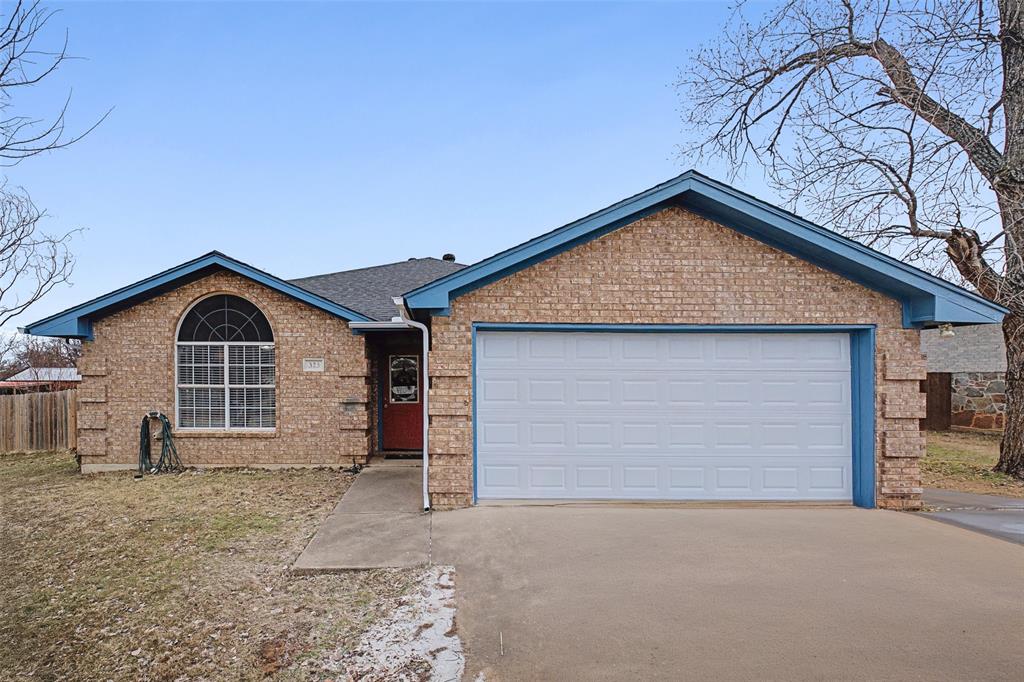323 Sage Trail Springtown, TX 76082 - Photo 4 of 32 a front view of a house with a yard and garage