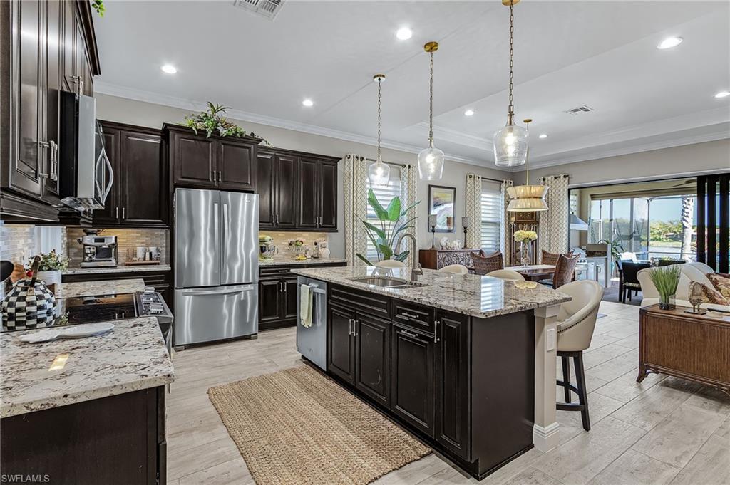 1434 Redona Way Naples, FL 34113 - Photo 22 of 47 a kitchen with stainless steel appliances kitchen island granite countertop a refrigerator a stove a sink a oven and a refrigerator