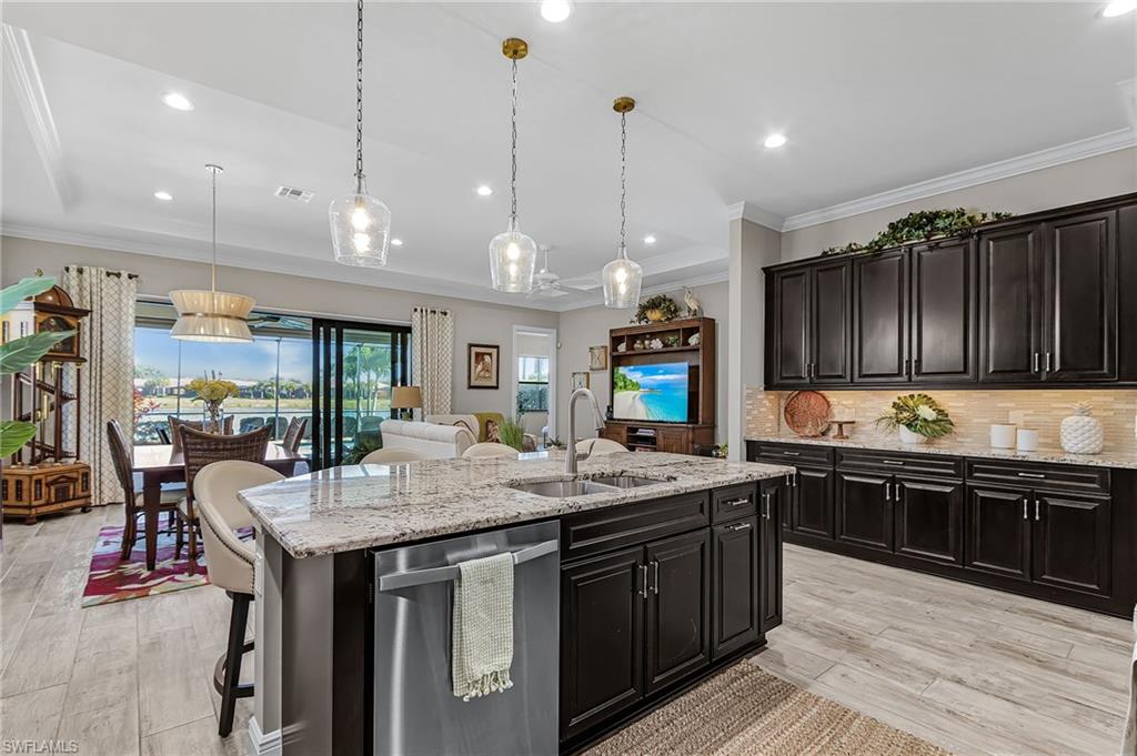 1434 Redona Way Naples, FL 34113 - Photo 25 of 47 a kitchen with stainless steel appliances granite countertop a sink a stove and a wooden floors